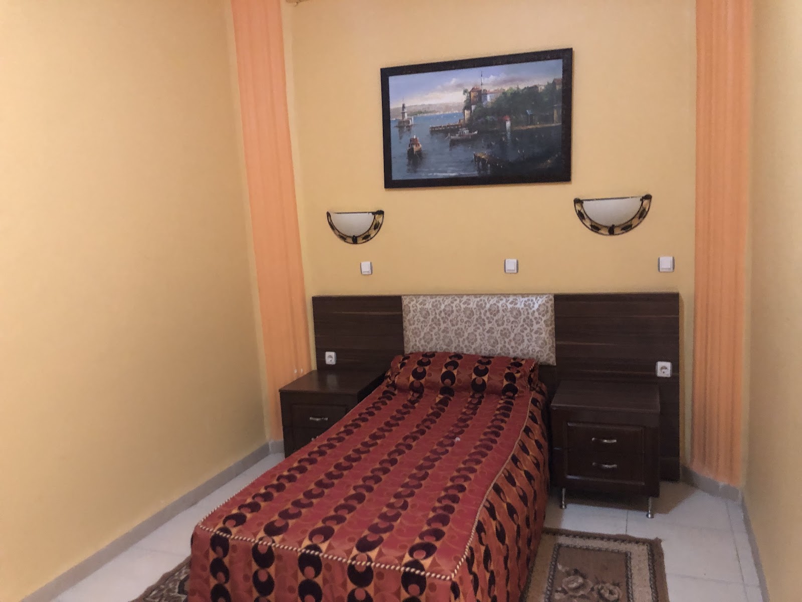 Single room with bed, wall art and bedside lamps
